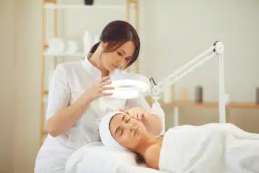 A dermal therapist doing a thorough check on a client’s face