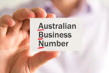 A hand holding a card with the words, Australian Business Number written on it