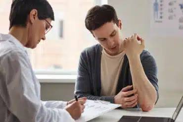 A skin doctor writing the patient’s condition on a chart board