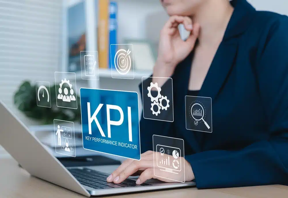 KPI Concept, Key Performance Indicators (KPIs). A professional working on a laptop with KPI icons.