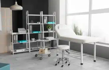Interior of modern medical office with couch and shelf unit